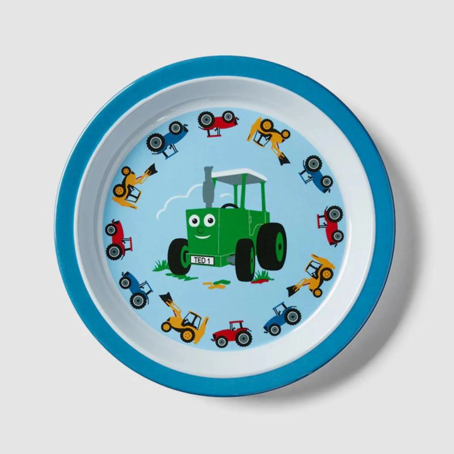 Children's plate with a green tractor and colorful vehicles on a blue rim against a light gray background