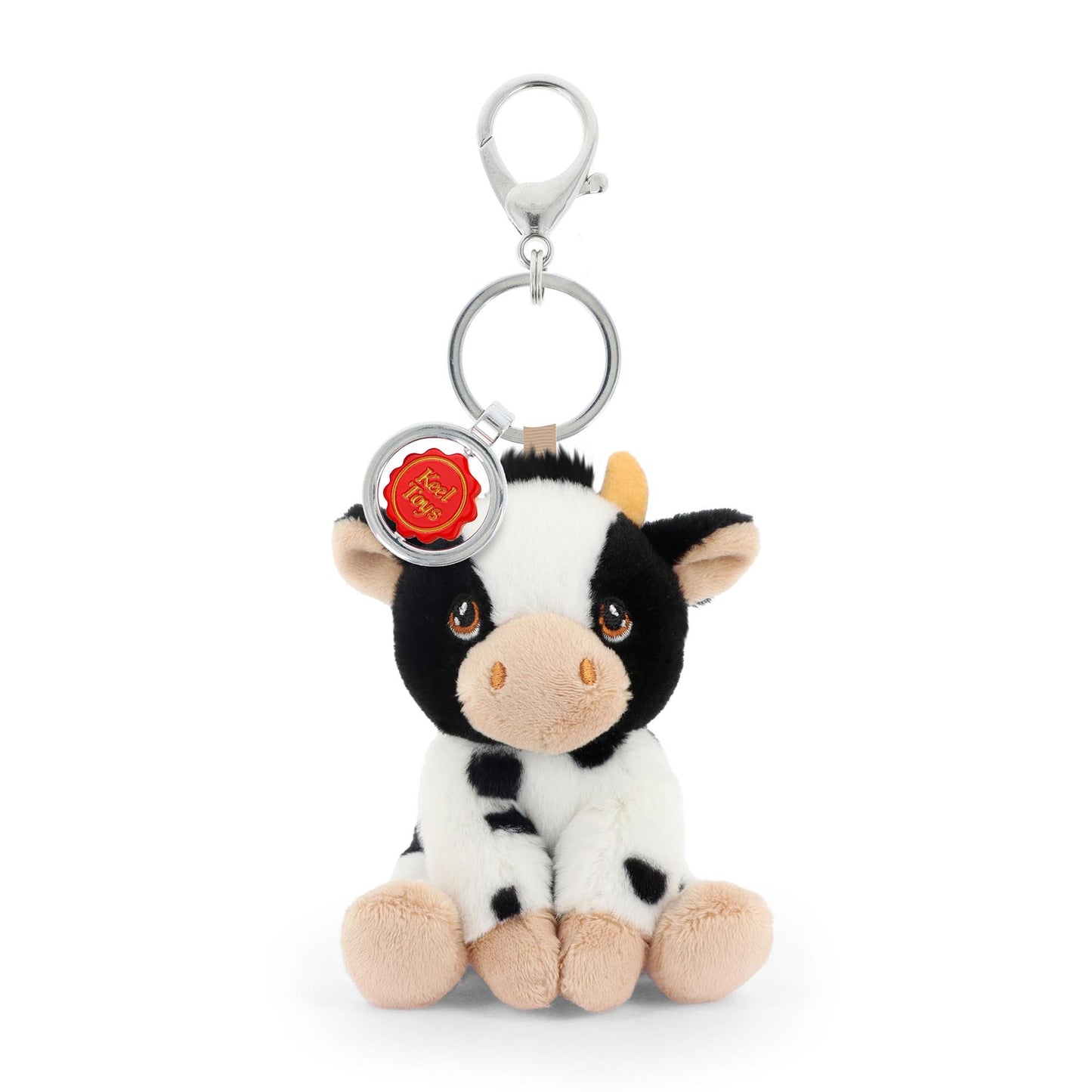Plush cow keychain with a tag on a white background