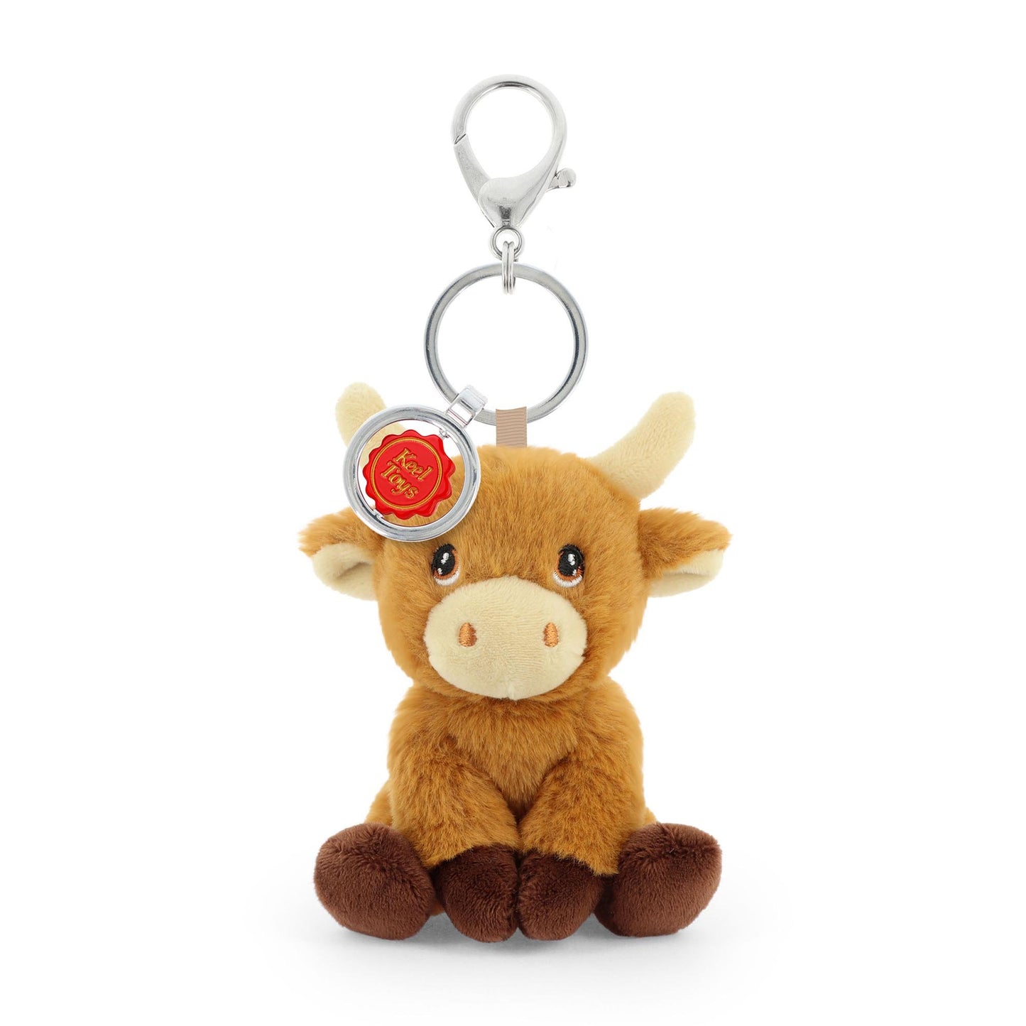Plush cow keychain with a silver ring and red emblem on a white background