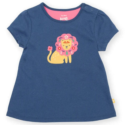 A navy blue short-sleeve baby t-shirt with a colorful cartoon lion graphic on the front, featuring a pink flower crown and a yellow body. The brand name 'k&te' is visible on the inner neck label.