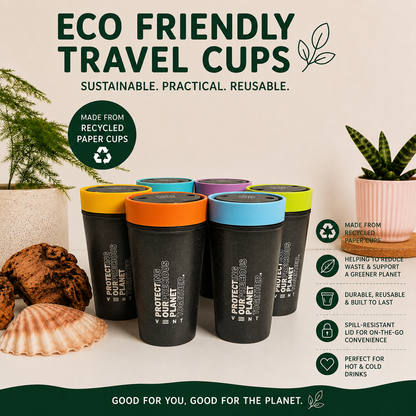 Six black reusable travel cups with colorful lids (yellow, orange, blue, purple, green, and black) arranged on a white surface with decorative plants and cookies. The image features text overlays highlighting the cups' eco-friendly, recycled paper cup origins and key features.