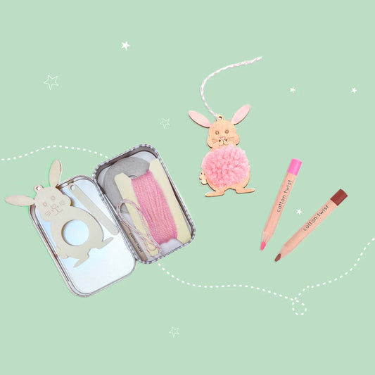 Set of stationery items including a pencil case, pens, and rabbit-themed accessories on a light green background.