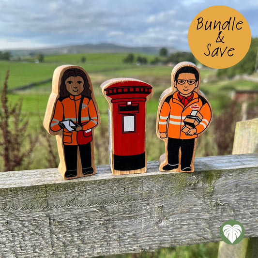 Three handcrafted wooden toy figures of a postwoman, a postman, and a red post box, displayed outdoors on a weathered wooden fence with a blurred green field and cloudy sky in the background. A yellow circular badge in the top right corner reads 'Bundle & Save'.