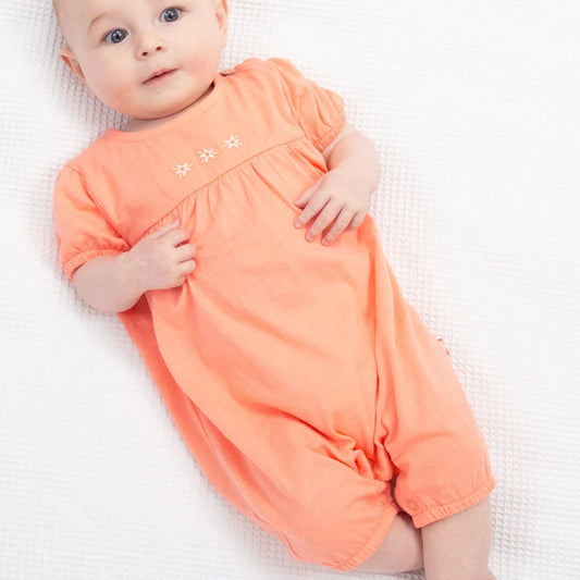 Baby wearing an orange outfit on a white background