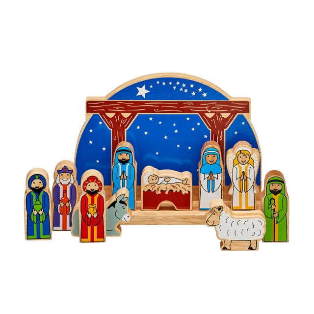 A wooden Christmas nativity set with colorful painted figures of Mary, Joseph, baby Jesus, three wise men, a shepherd, a donkey, and a sheep, arranged under a blue starry sky backdrop on a white background.