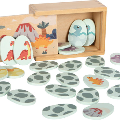 A children's dinosaur egg toy set with a wooden box and many oval egg-shaped pieces printed with dinosaur and footprint designs, arranged on a white background.