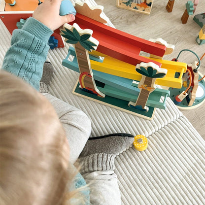 Child playing with a colorful wooden toy on a carpeted floor.